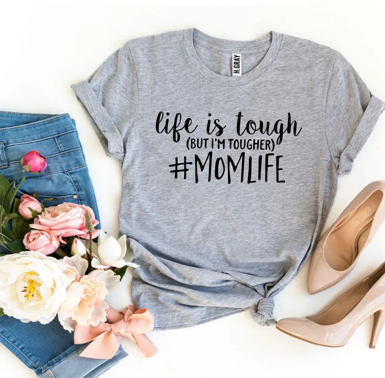 Close-up of white #Momlife T-shirt fabric with printed black and pink text design