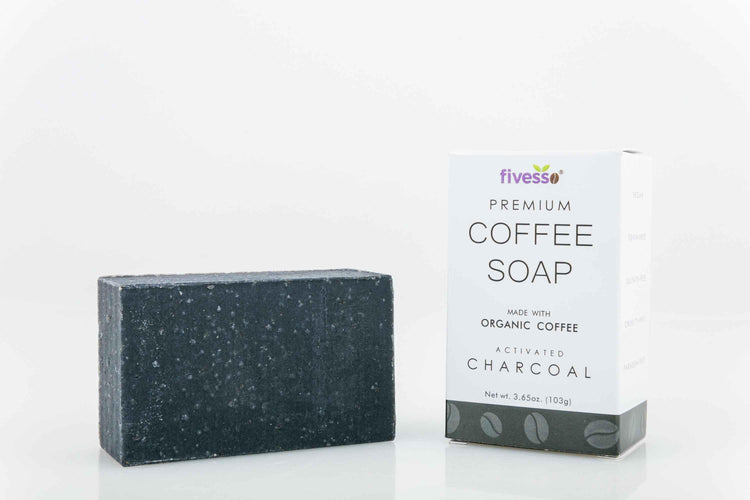 Hand holding a rectangular charcoal coffee soap bar with packaging labeled Activated Charcoal Premium Coffee Soap Bar.