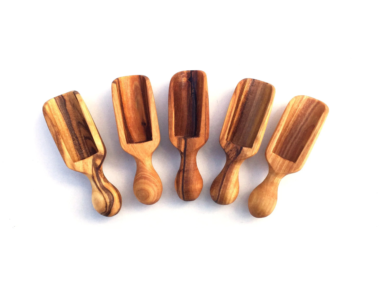 Set of five small 6 cm salt scoops made of wood, arranged on a white surface.