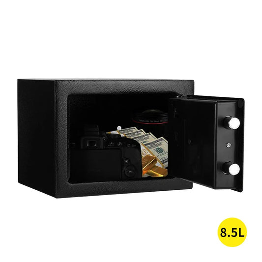 Closed black 8.5L electronic safe with digital keypad on top corner on a wood surface.