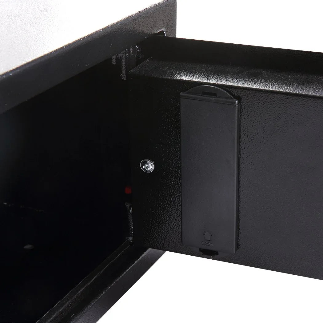 Safe mounted inside a wooden cabinet shelf for discreet secure storage.