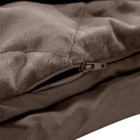 Soft mink colored weighted blanket draped over chair in minimalist styled bedroom corner.