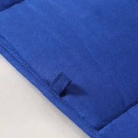 Weighted blanket spread out on a bed highlighting its insulation and quality stitching.