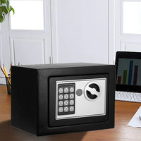 Electronic safe placed on office desk next to keyboard and documents for security.