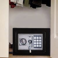 Electronic safe placed on white surface with two override keys visible beside it.