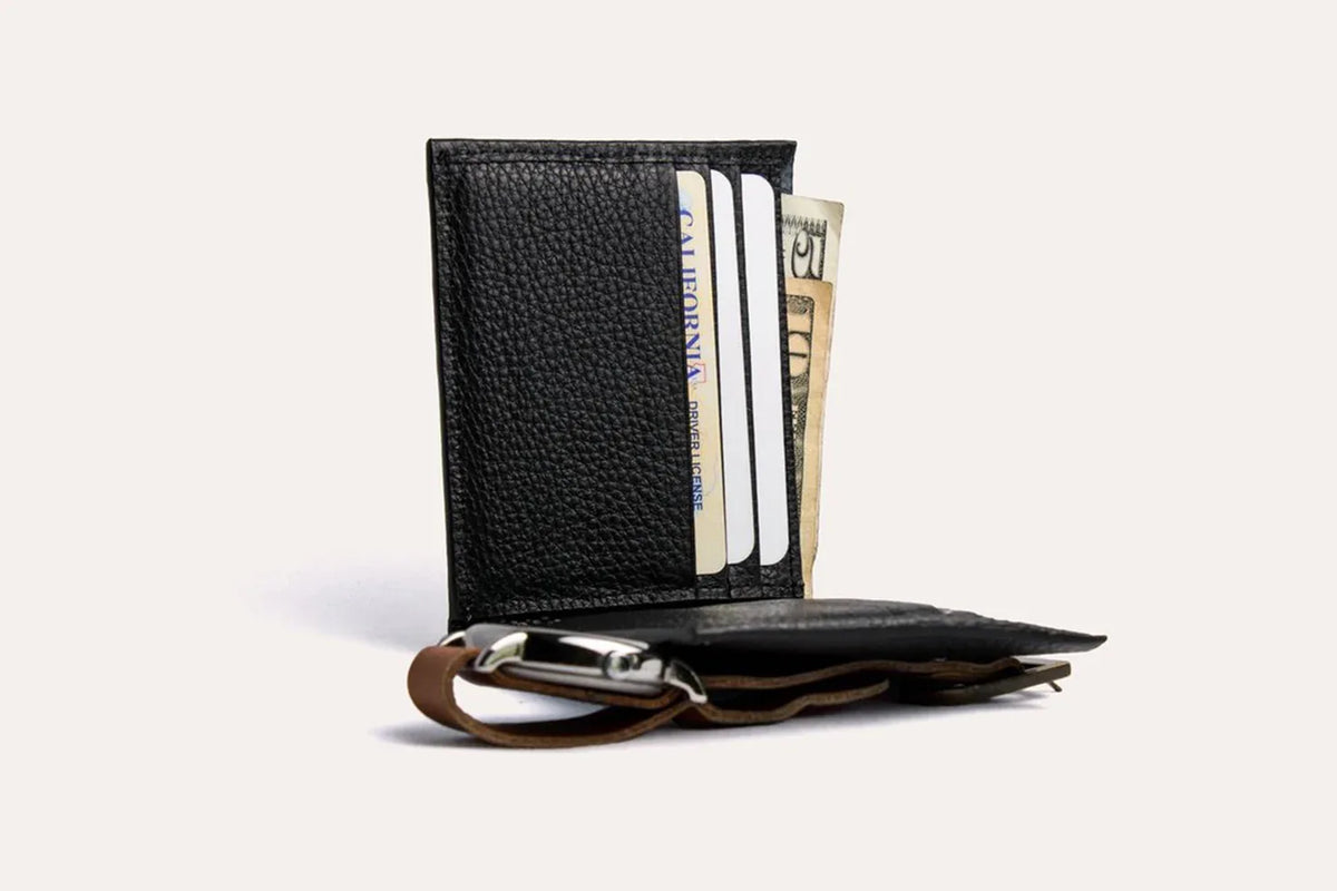 Classic leather wallet flat on white background, showing pebbled texture and contrast stitching.