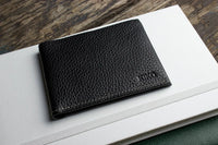 Black leather wallet fully opened to show organizational features and craftsmanship.