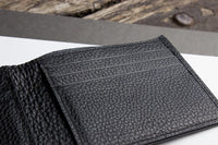 Black wallet interior with multiple compartments and self-lined bill section.