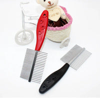 Hand holding red pet grooming comb demonstrating comfortable grip and round needles