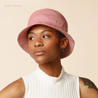 Model wearing dark brown cotton bucket hat with flat brim, facing forward.