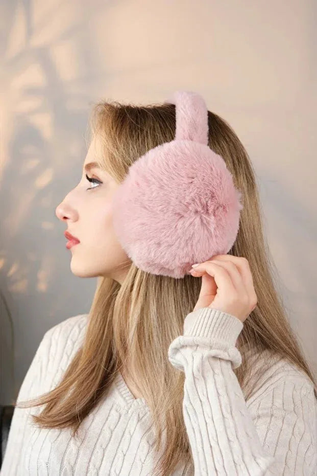 Soft pink plush earmuffs worn on a head form, demonstrating full ear coverage and cold weather protection.