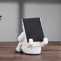Side view of the astronaut phone stand showing detailed helmet and arms holding the phone.