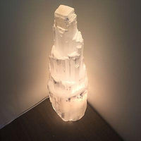Close-up of translucent selenite crystal lamp showing natural striations and glowing softly.