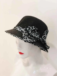 A soft bucket hat with a chic animal print, featuring a stylish bow tied at the side.