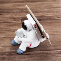 Astronaut phone stand angled showing its compact 10.6 by 7.3 cm size.