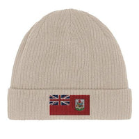 Unfolded green organic cotton beanie laid flat with visible Bermuda flag patch