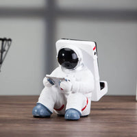 Astronaut mobile stand on a student desktop with books and stationery in the background.
