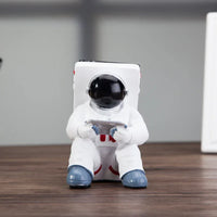 Back view of white astronaut mobile phone stand highlighting resin material texture.