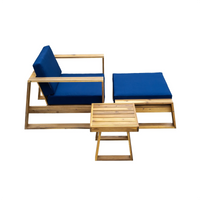 Side angle of acacia wood lounge chair paired with ottoman featuring blue cushions