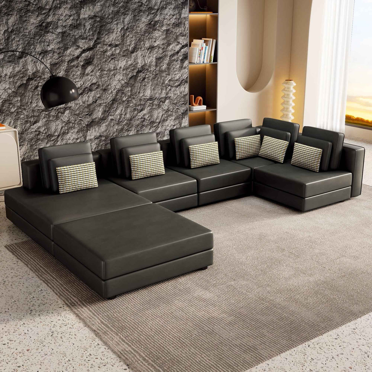 Large black modular sectional sofa with chaise lounge, upholstered in fabric, shown in a spacious living room.
