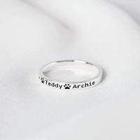 18K gold plated dog name ring displayed on a wooden surface.