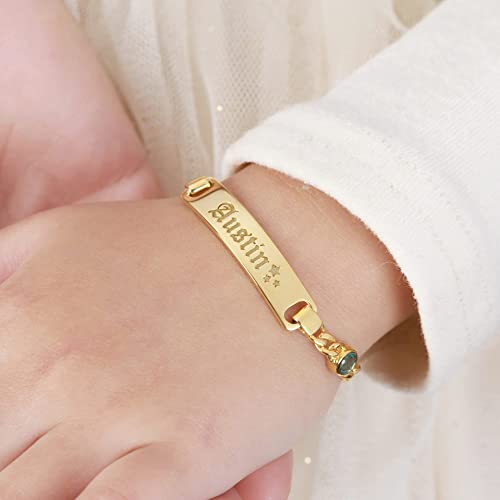 Close-up of personalized toddler bracelet featuring name engraving and small birthstone on silver band.