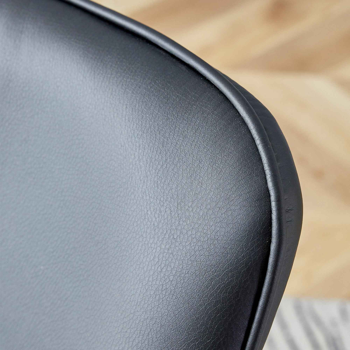 Detailed view of black metal legs and frame of minimalist dining chair