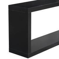 Black square entrance table under a round mirror in a minimalist styled entryway