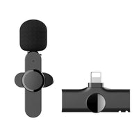 Wireless microphone components laid out including microphone, clip, and charging case.