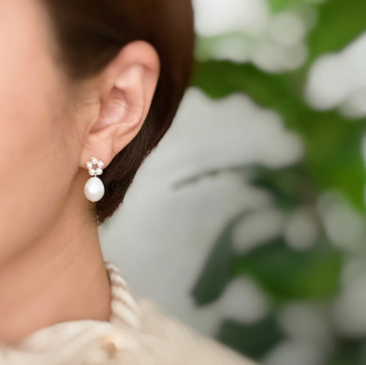 Freshwater pearl drop earrings displayed against dark fabric backdrop enhancing contrast.