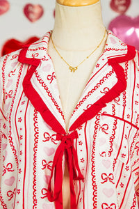 Pajama shorts laid flat featuring stripes and heart prints with ribbon tie detail.