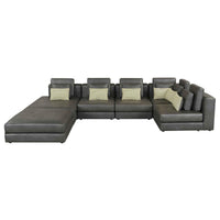 Large black modular sectional sofa with a chaise lounge, upholstered in soft fabric, arranged in a spacious room.