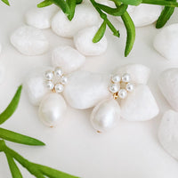 Close-up of circular pearl bead arrangement on a gold-plated drop earring.