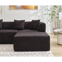 Black polyester L-shaped couch with four plush seats positioned in corner space.