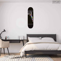 Graffiti hummingbird skateboard mounted on a bedroom wall above a bed
