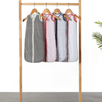 Collection of wearable baby sleep bags in white, beige, and pale pink colors.