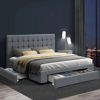 Grey fabric bed frame with storage drawers closed, showing clean tailored design details.