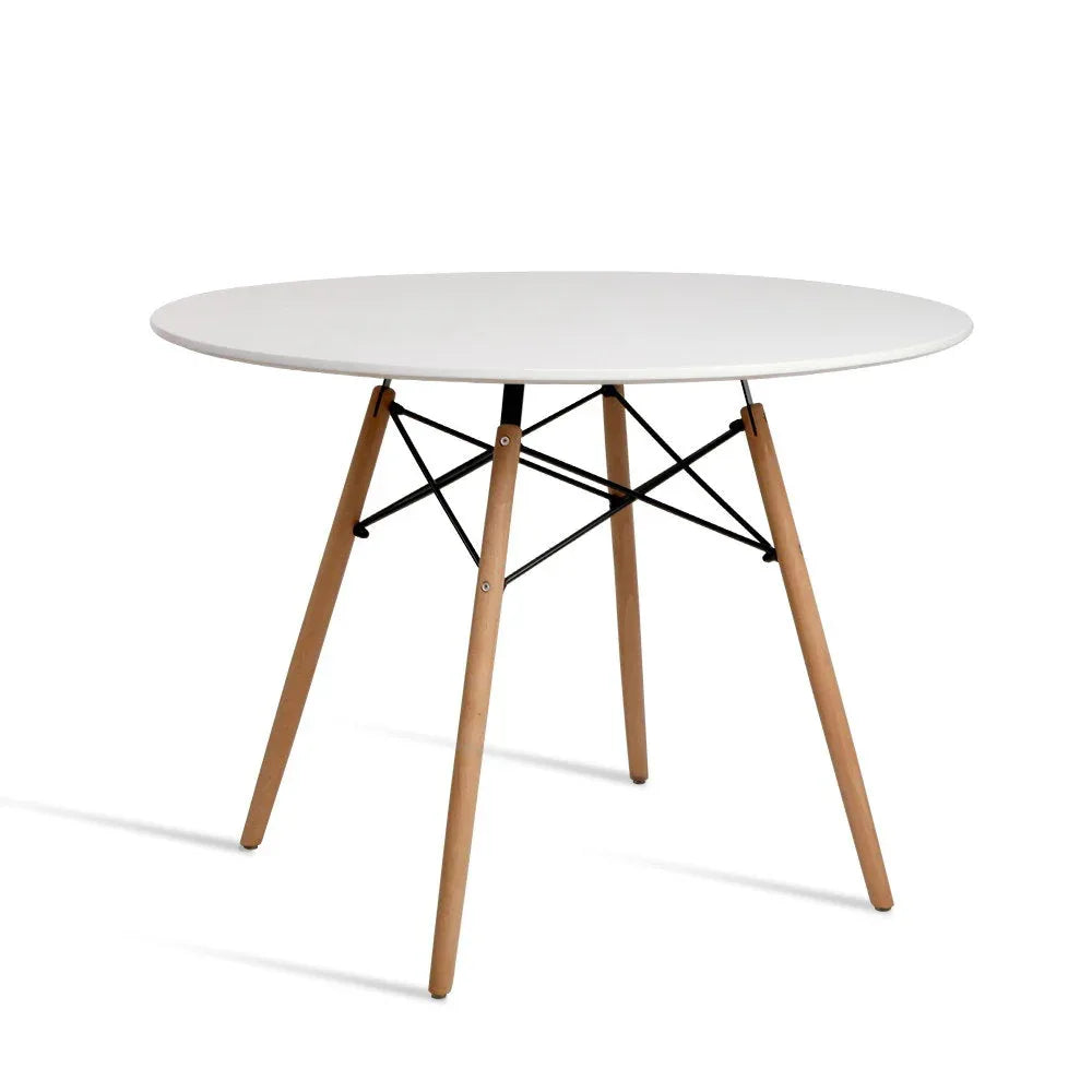 Round white dining table with wooden Eiffel-style legs on a light floor