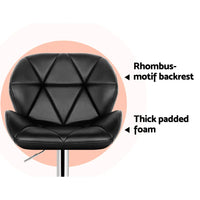 Side view of black faux leather bar stool with chrome frame and semi-circular footrest