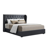 Charcoal fabric queen bed frame with padded, tufted headboard and wooden slat base in a minimalist bedroom.