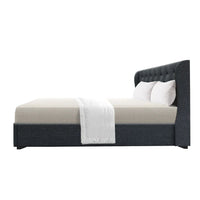 Close-up of tufted headboard with stitched details on charcoal fabric queen bed frame.