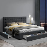 King bed with charcoal tufted headboard and fabric storage drawers in modern bedroom setup with neutral decor.