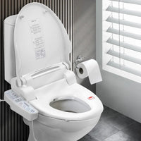 White bidet toilet seat with electronic control panel beside traditional toilet.