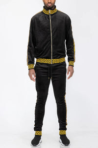 Close-up of black and gold velour track jacket showing fabric texture and zipper details.