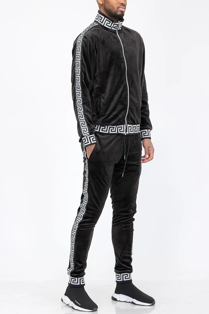Close-up of black velour fabric with subtle stripe detail on men's track pants.