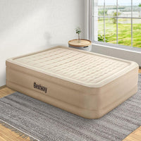 Fully inflated Bestway queen air bed placed in a bedroom with a pillow on top.