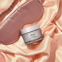 Close-up of PRAI Beauty Platinum Firm & Lift Night Creme jar on a white background highlighting the cream texture