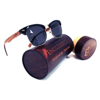 Real walnut wood club style sunglasses with polarized lenses placed next to bamboo case on white background.