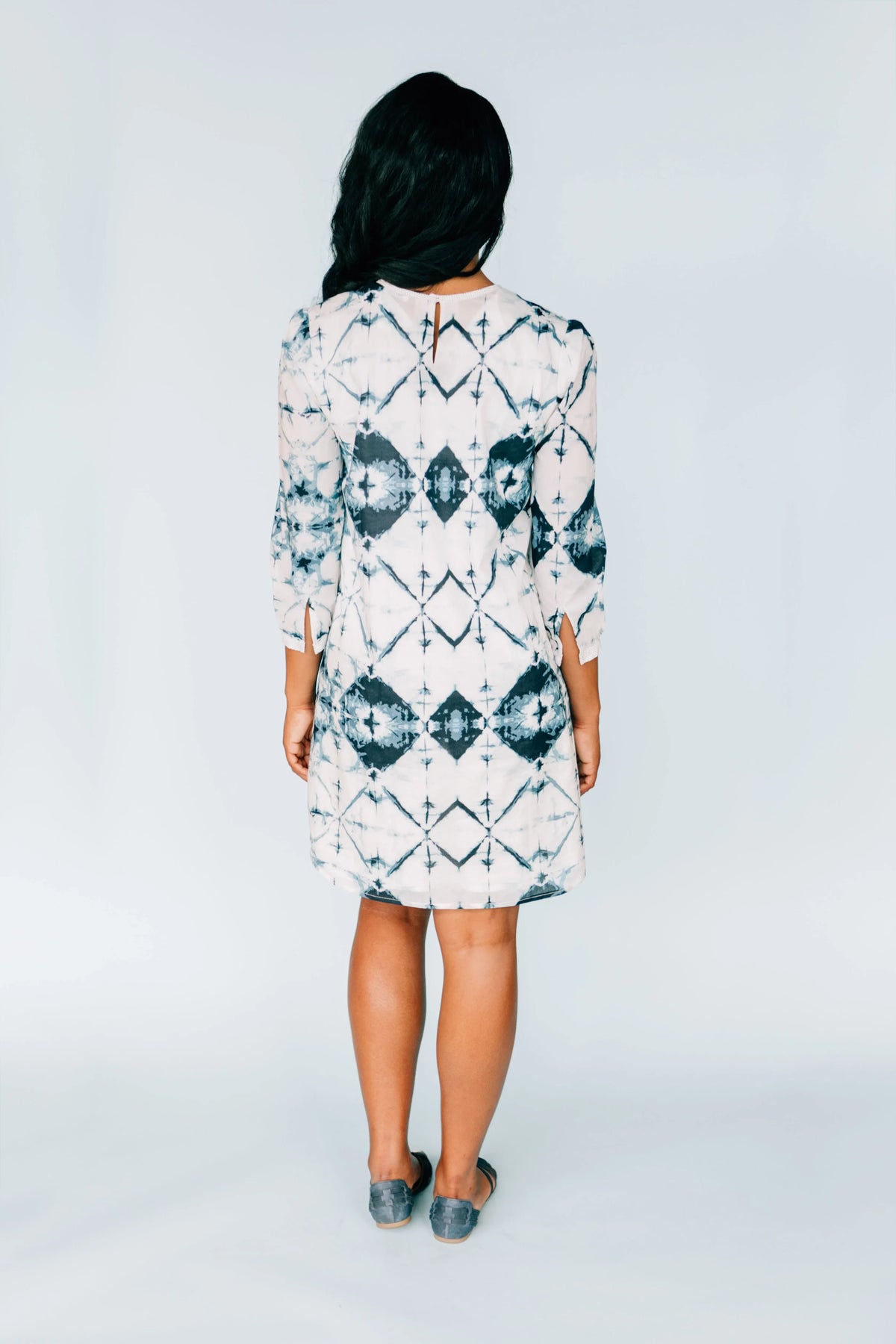 Back view of model in Inkwell Dress showing keyhole button closure and flowing fabric.