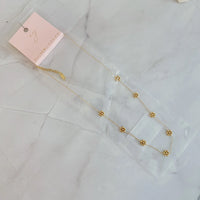 Close-up of necklace clasp and extender chain in gold finish on white background.